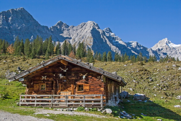 Traditional wooden barn at Ladizalm with woodland and the Karwendel mountains behind