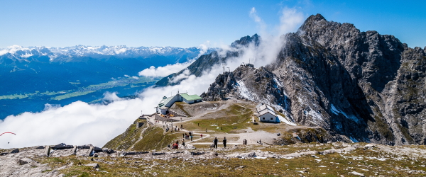 Looking down on the Nordkette Cable car station at the start of the Goetheweg. Low clouds brush the mountain tops and below the Inn Valley is revealed
