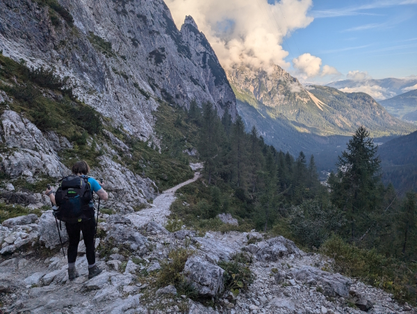A hiker descending through Val Fiscalina towards Sexten at the end of the Alta Via 9