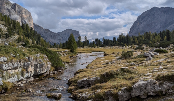 Hiking through Val Fanes. Grassy pastures are surrounded by rocky cliffs