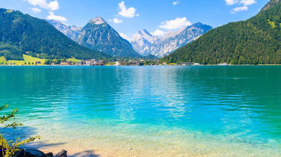 The clear blue waters of Achensee (Achen Lake) on the edge of the Karwendel National Park. At the other side of the lake is the village of Maurach and behind are the towering alpine peaks.