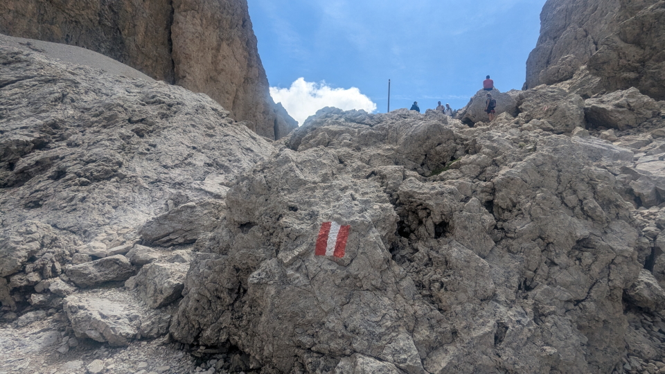 A red and white waymark on the Alta Via 9 near Rifugio Toni Dimetz