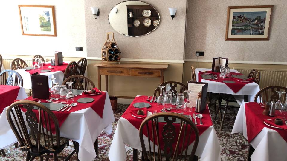 A scene of breakfast tables laid up ready, in the English Lake District, fairly typical of a B&B