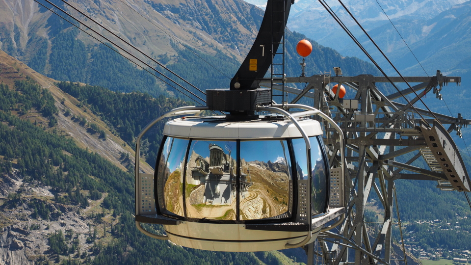 A cable car shines in the sun, on the Walker's Haute Route