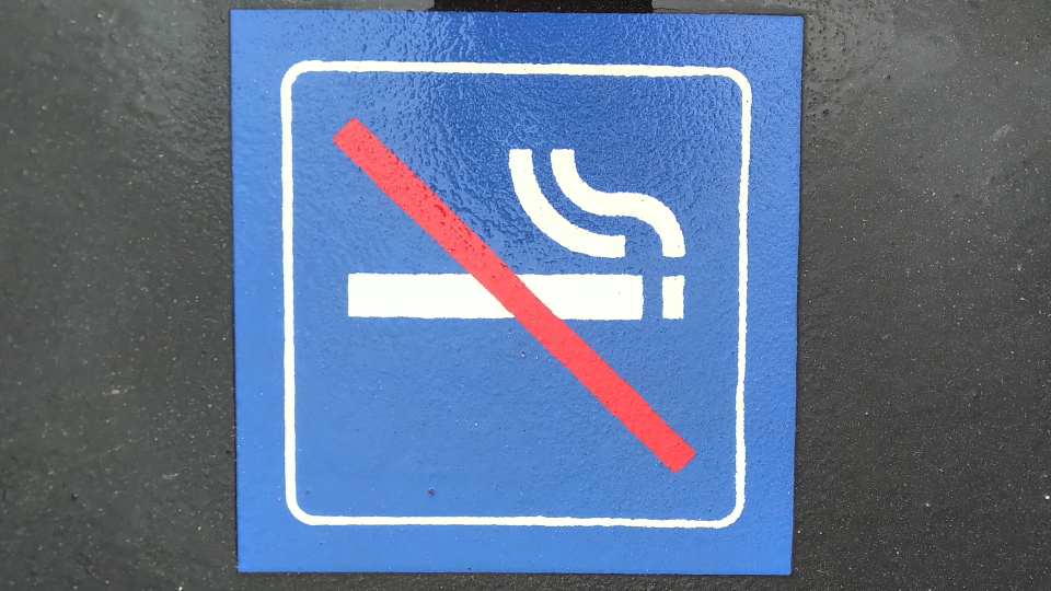 A Swiss no-smoking sign, on a damp station platform