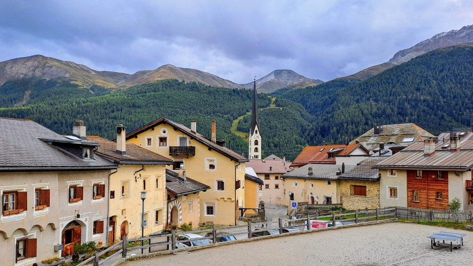 The spire in Zuoz rises above the village, a ski slope behind
