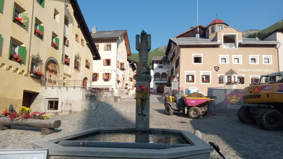 A tractor and a water fountain in the Swiss village of Zuoz