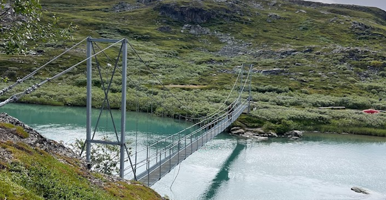 A suspension bridge over a river between Alesjaure and Tjakta
